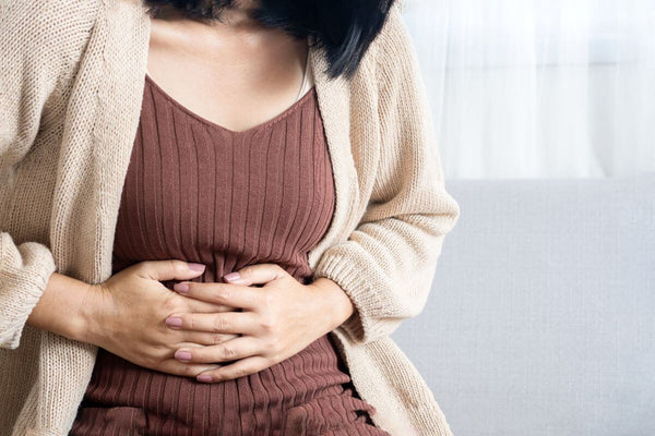 Woman holding her stomach due to gas and bloating