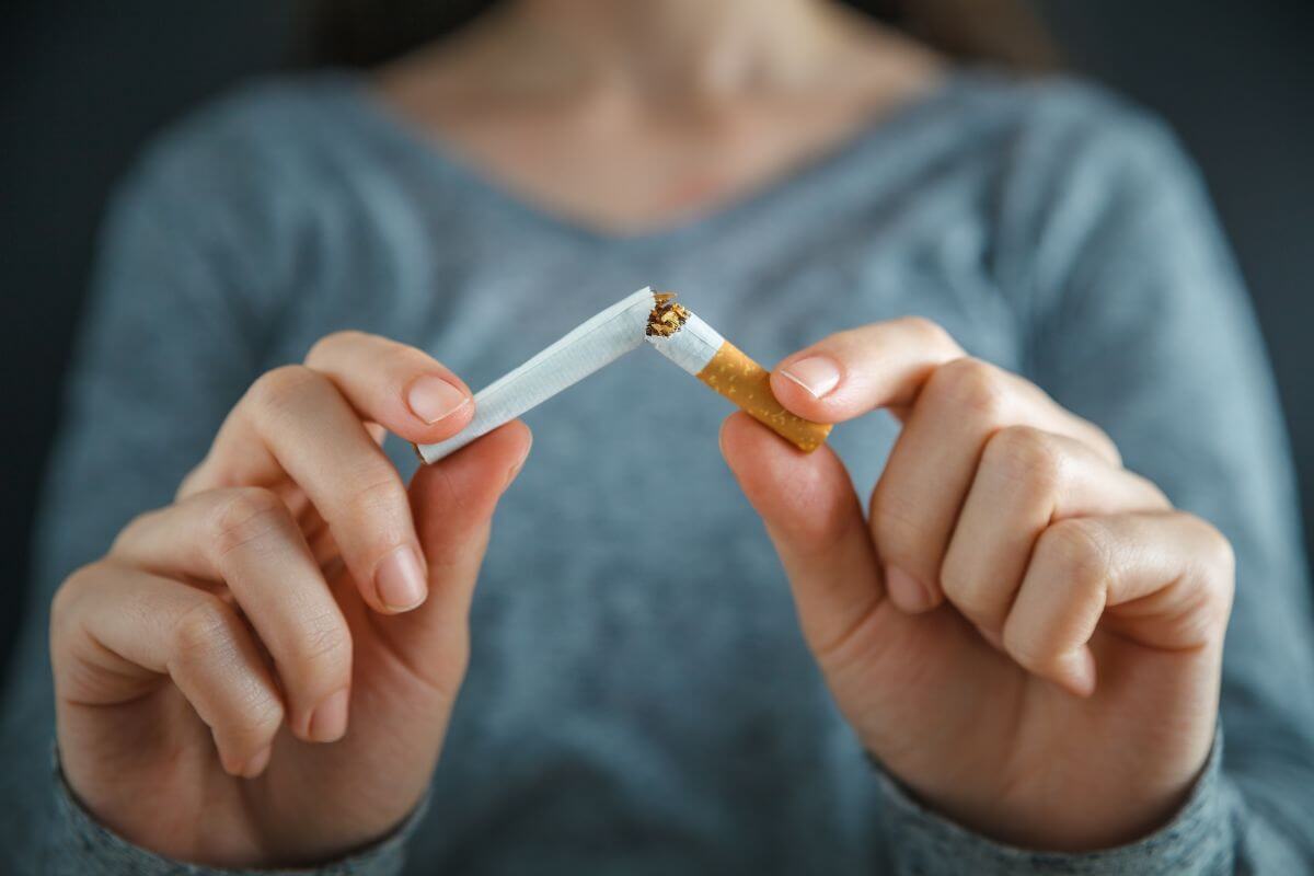 woman breaking cigarette in half